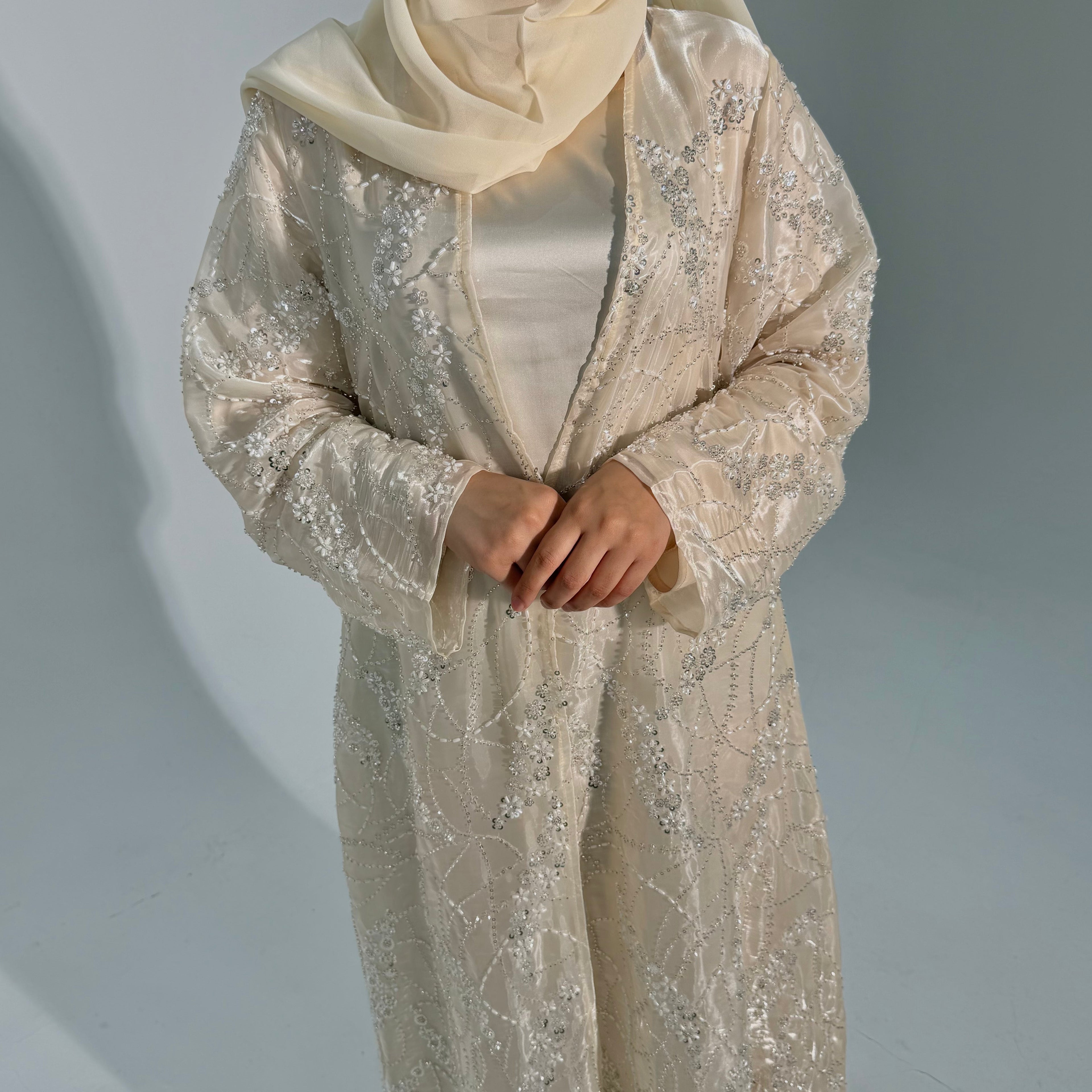 Beige embroidered outfit with a matching hijab on a plain background